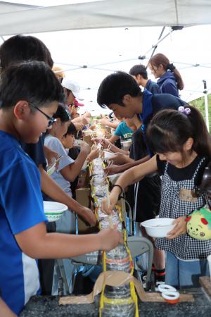 流しそうめをする学生と児童